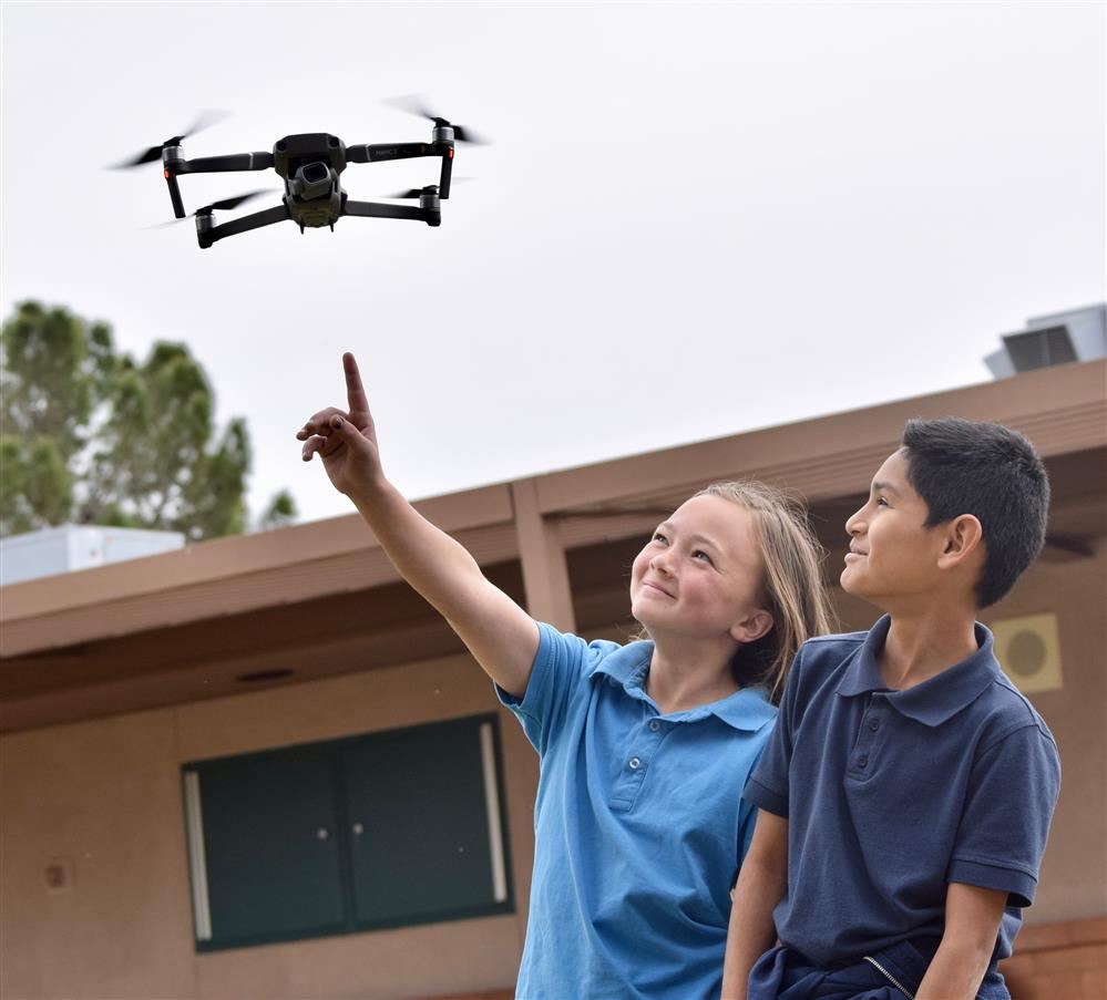 Children pointing at drone